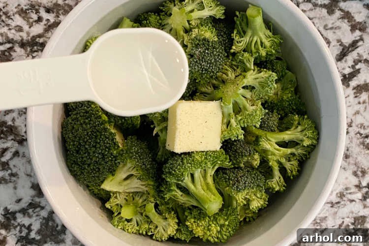 Broccoli florets in a bowl with water added, before microwaving