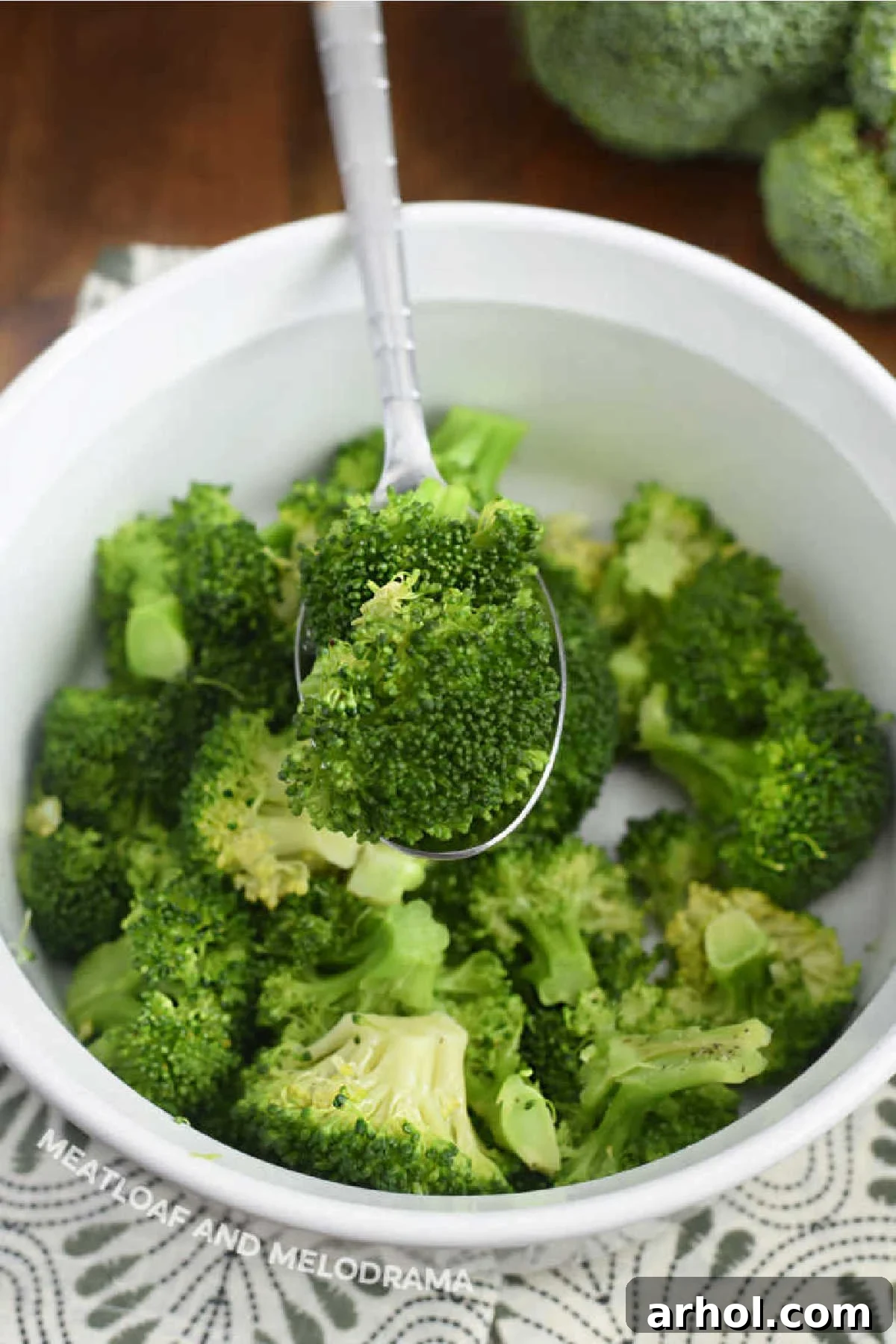 Steamed microwave broccoli on a serving spoon in a bowl