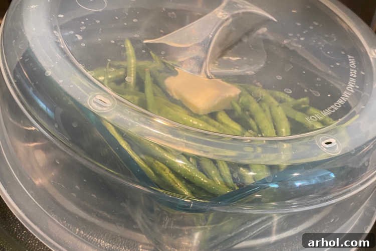 Green beans steaming in a covered microwave-safe dish
