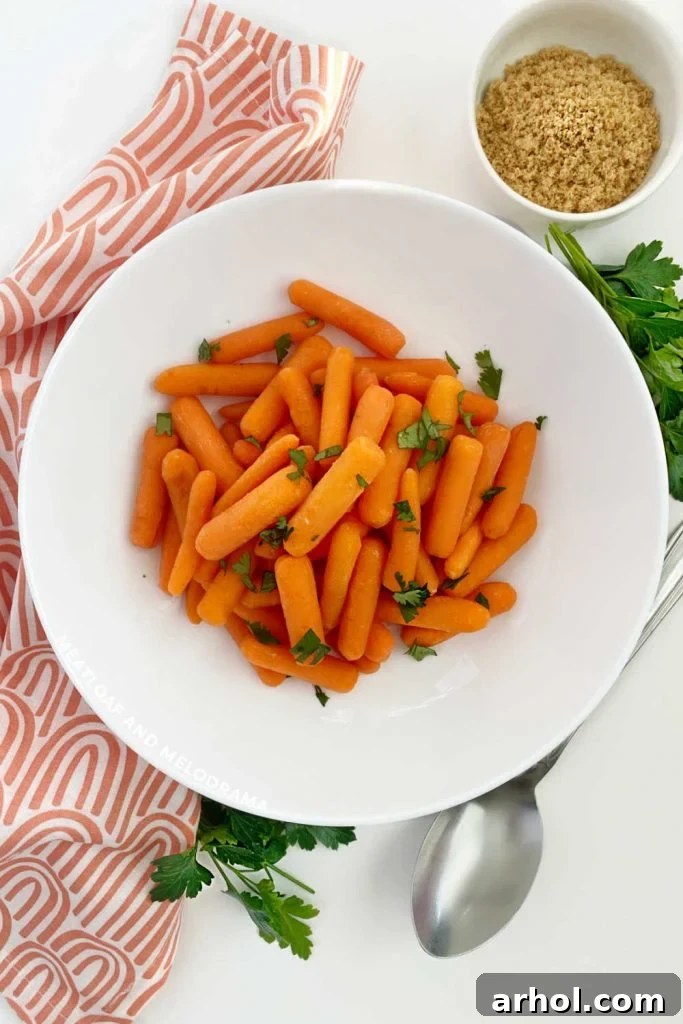 Vibrant microwave carrots in a white serving bowl, garnished with fresh parsley.