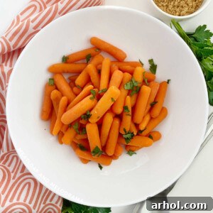 Microwave cooked carrots in a white bowl, ready to serve.