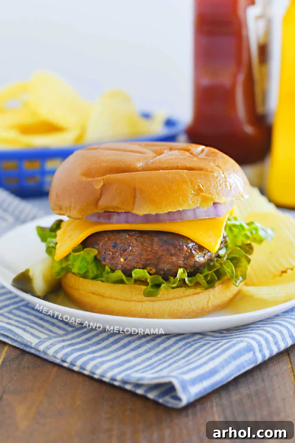 Classic Lipton onion soup burger with melted cheese in a toasted hamburger bun, ready to be served on a rustic wooden table.