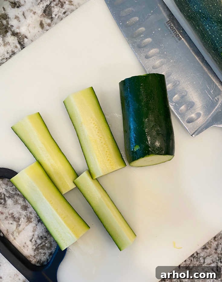 Fresh zucchini cut into uniform spears, ready for seasoning.