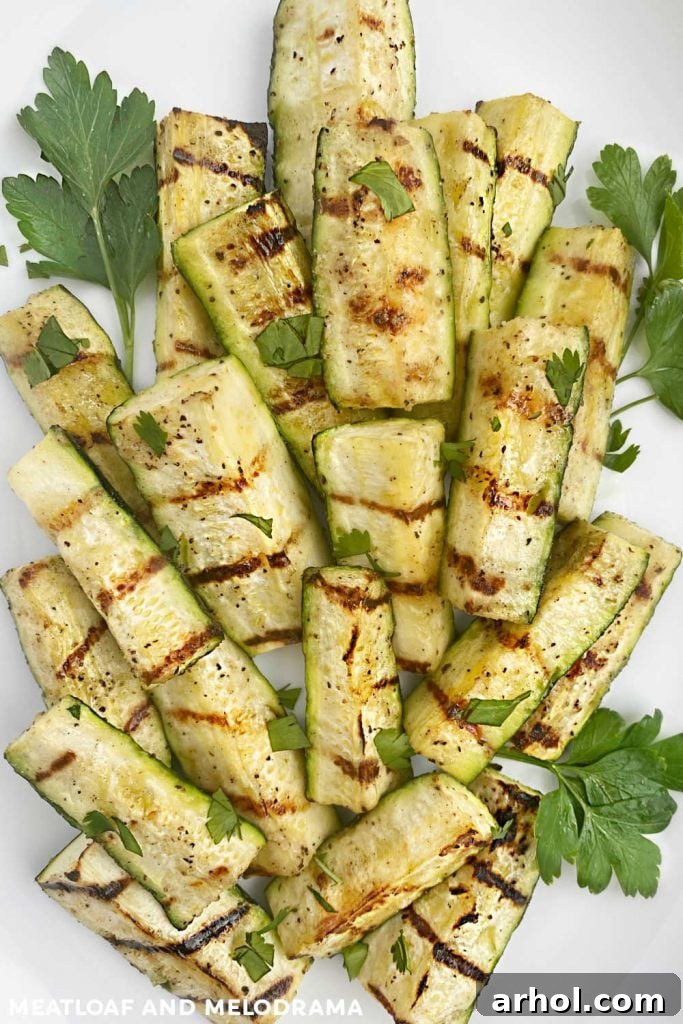 Close-up of perfectly grilled zucchini spears on a platter, highlighting the smoky char marks and tender texture.