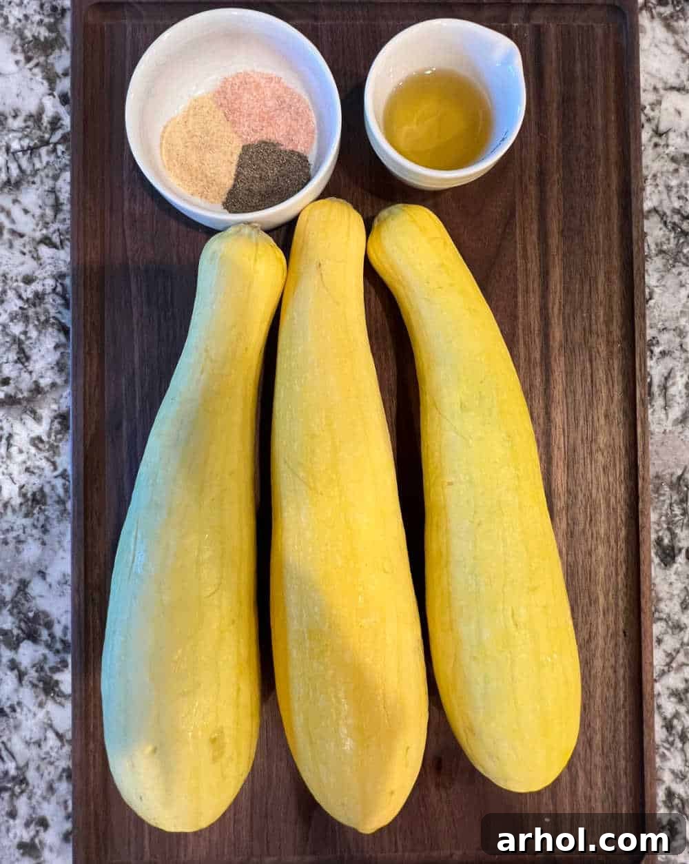 Freshly cut yellow squash halves, ready for grilling, showcasing their bright color and smooth texture.