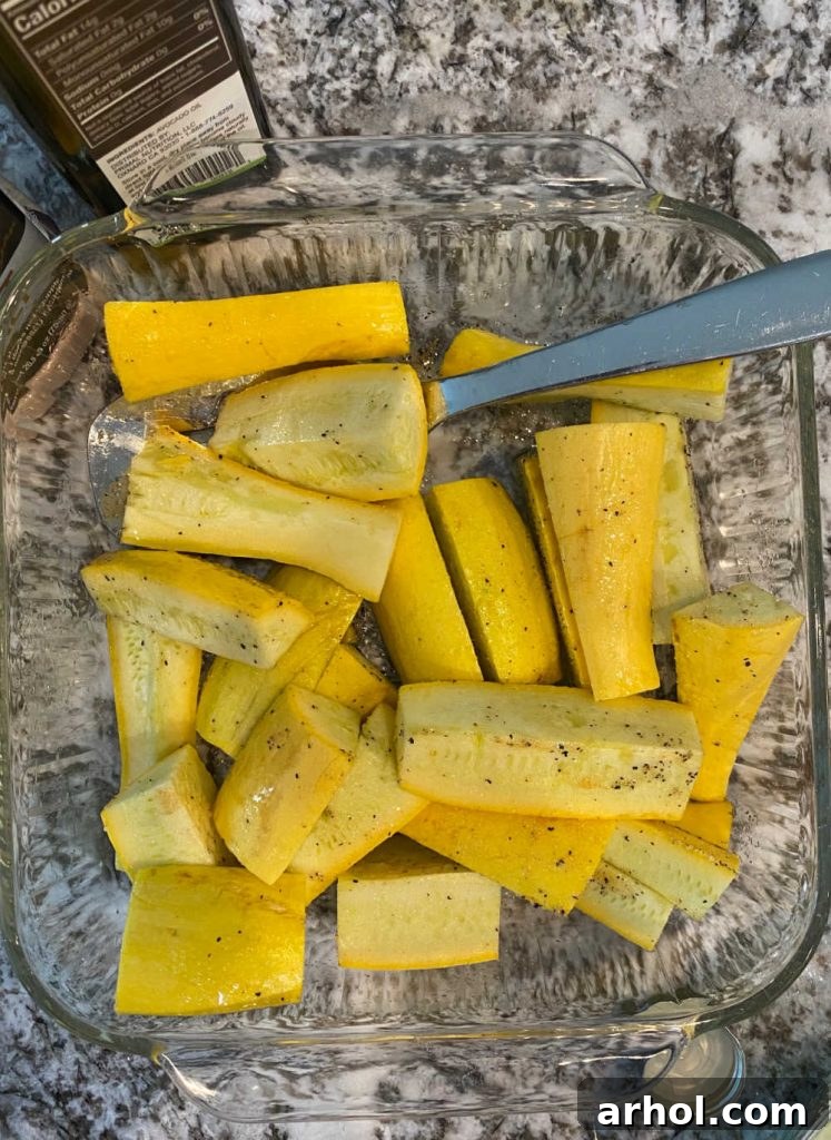 Yellow squash wedges being tossed in a mixing bowl with avocado oil and various seasonings, preparing them for grilling.