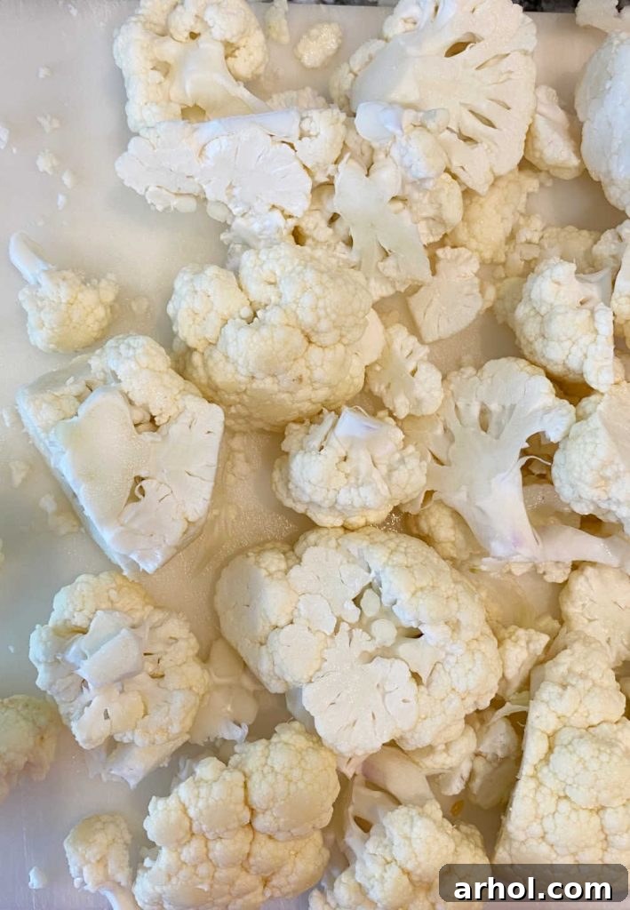 Cut raw cauliflower florets ready for steaming in a microwave-safe bowl.