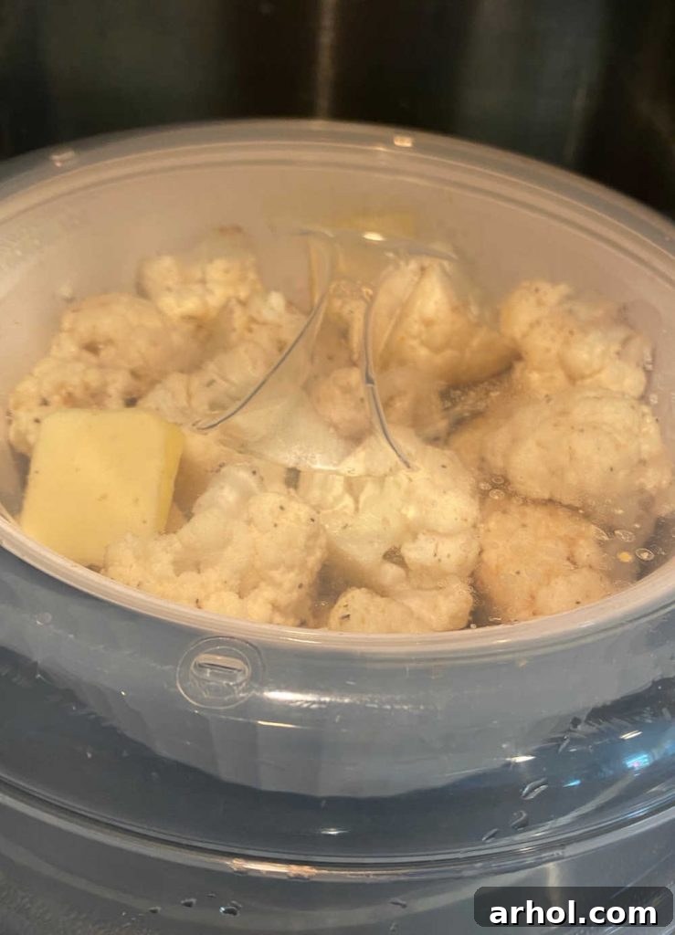 Cauliflower florets steaming inside a microwave oven.