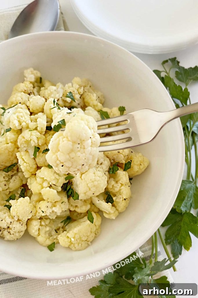 A single fork-tender steamed cauliflower floret, ready to eat.