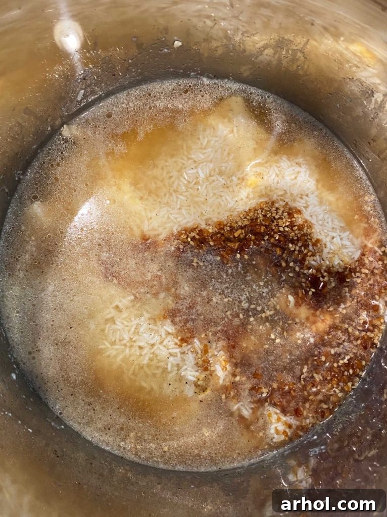 Layered ingredients – chicken, rice, and teriyaki sauce – inside the Instant Pot before sealing and cooking.