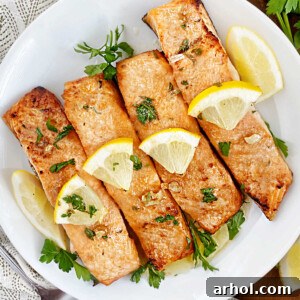 ninja foodie grill salmon on a plate with lemon garlic butter sauce and parsley