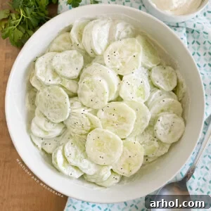creamy cucumber salad with sour cream in a white serving bowl