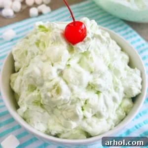 bowl of pistachio salad with pineapple and maraschino cherry on top