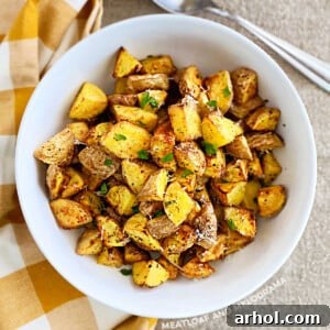 crispy air fryer baby potatoes with parmesan cheese and parsley in white serving bowl