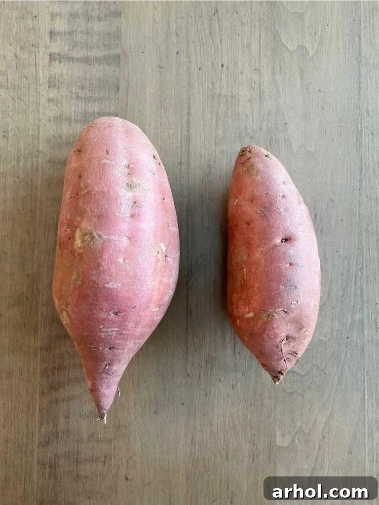 Microwave Sweet Potato in Minutes 3 Sweet potato size comparison - one large sweet potato next to one small sweet potato, uncooked