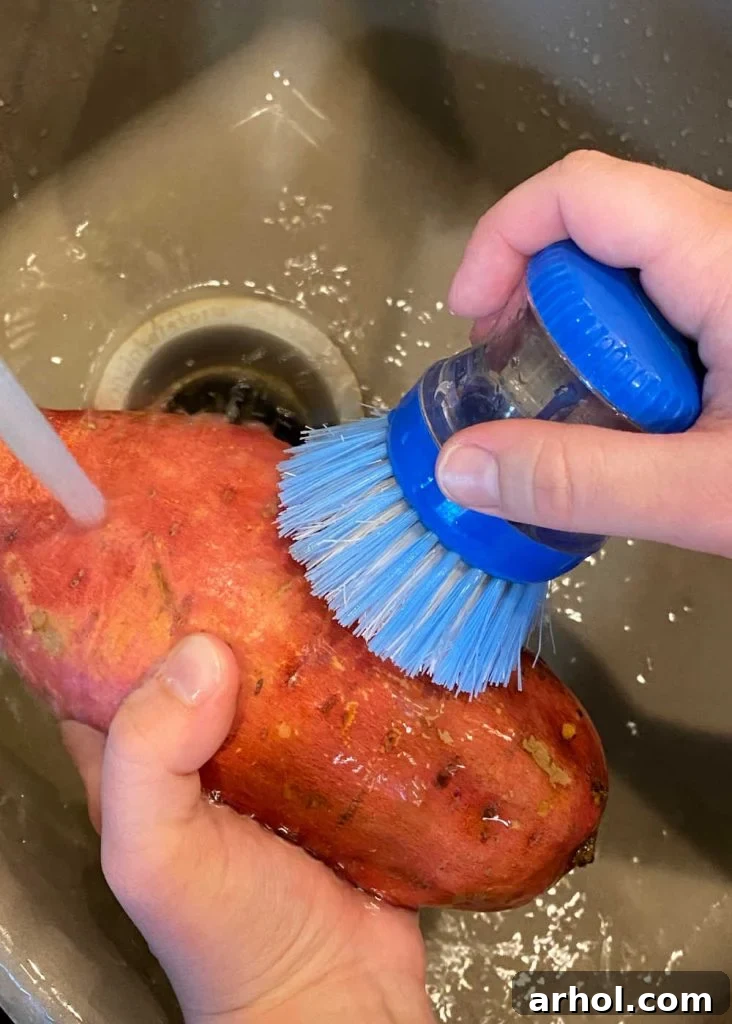 Microwave Sweet Potato in Minutes 4 Scrubbing a raw sweet potato with a brush under running water