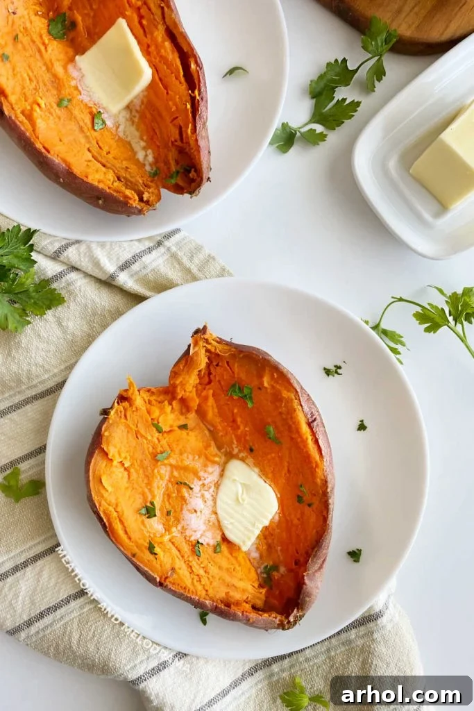 Microwave Sweet Potato in Minutes 6 Two baked sweet potatoes with butter and parsley on a table, ready to be served