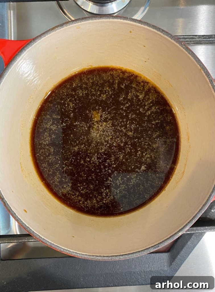 A small saucepan on the stove filled with rich, homemade teriyaki sauce, simmering to perfection.