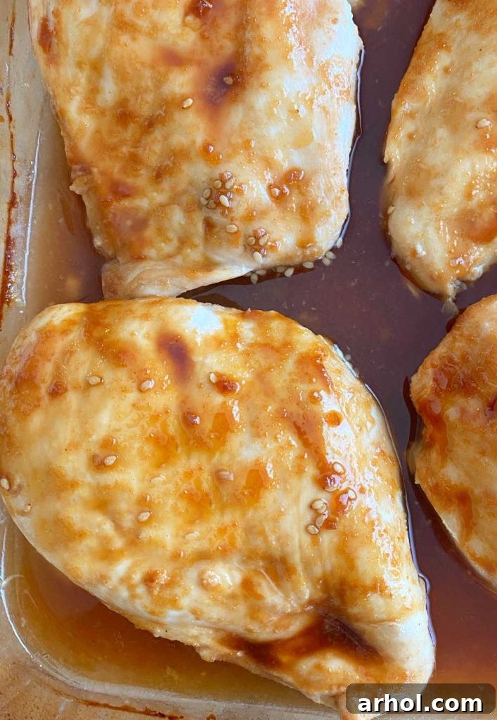 Tender chicken breasts glistening with rich teriyaki sauce, baked to perfection in a ceramic baking dish.