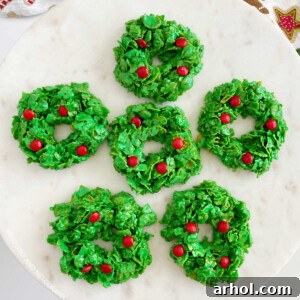 Christmas cornflake wreath cookies with red candies on cake stand