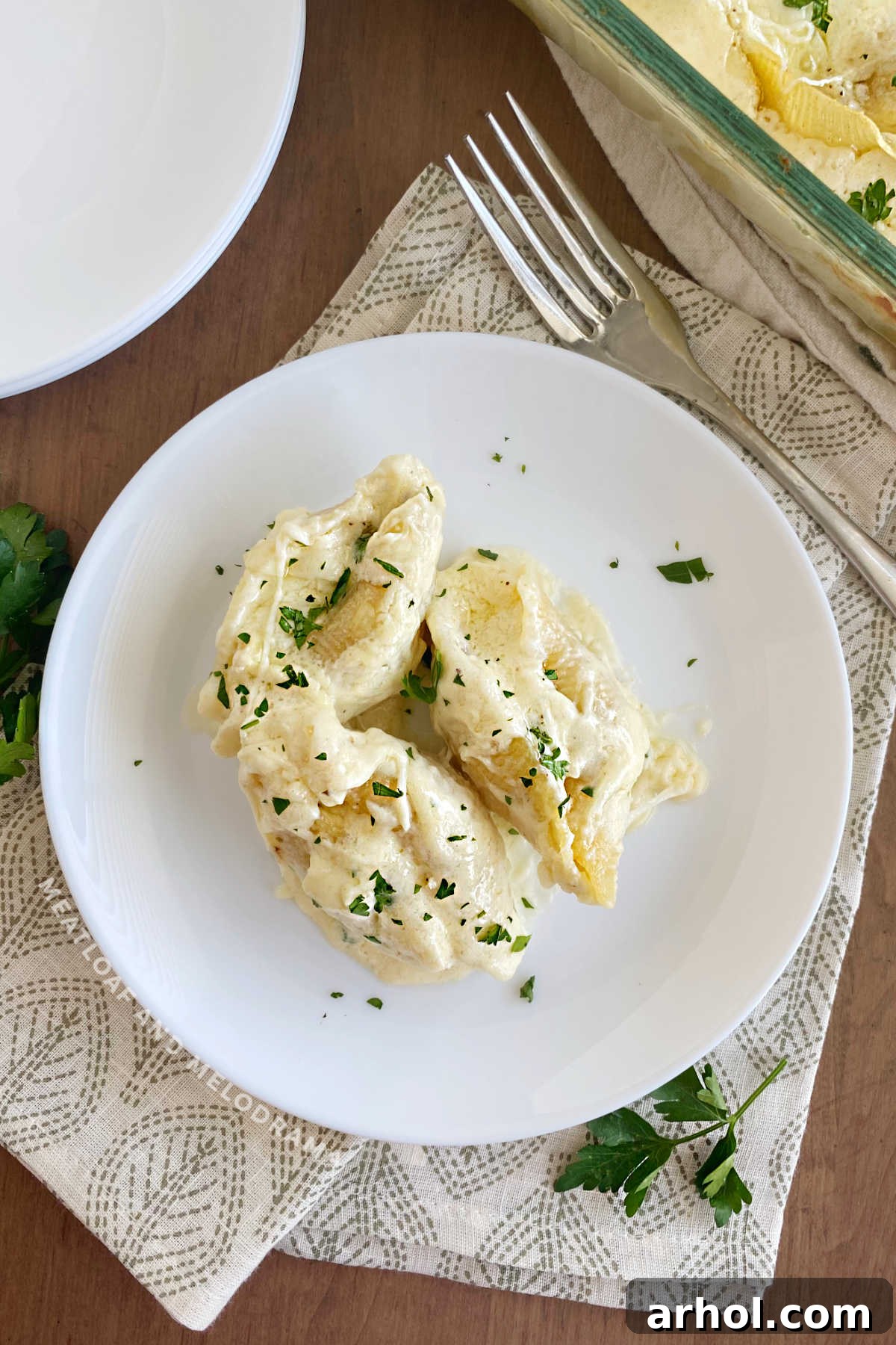 chicken Alfredo stuffed shells topped with parsley on the table