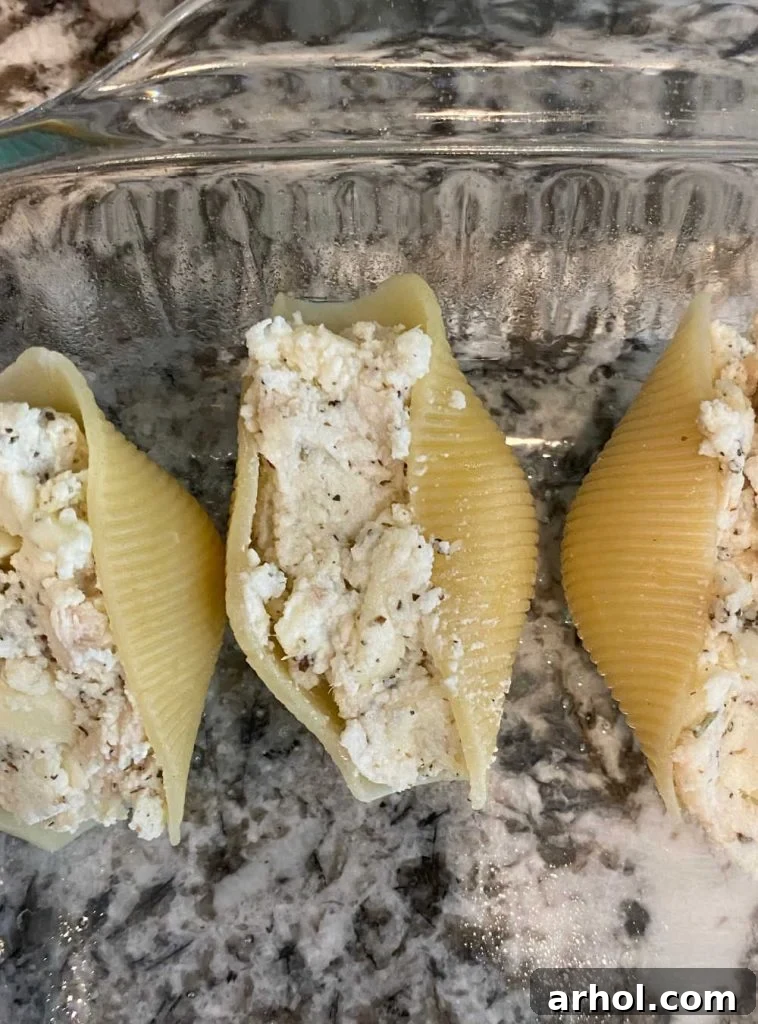 jumbo pasta shells stuffed with chicken and ricotta cheese in glass dish