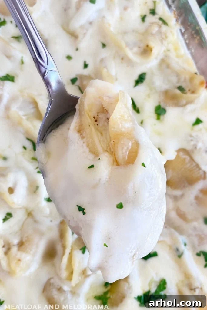 chicken alfredo stuffed shells on serving spoon