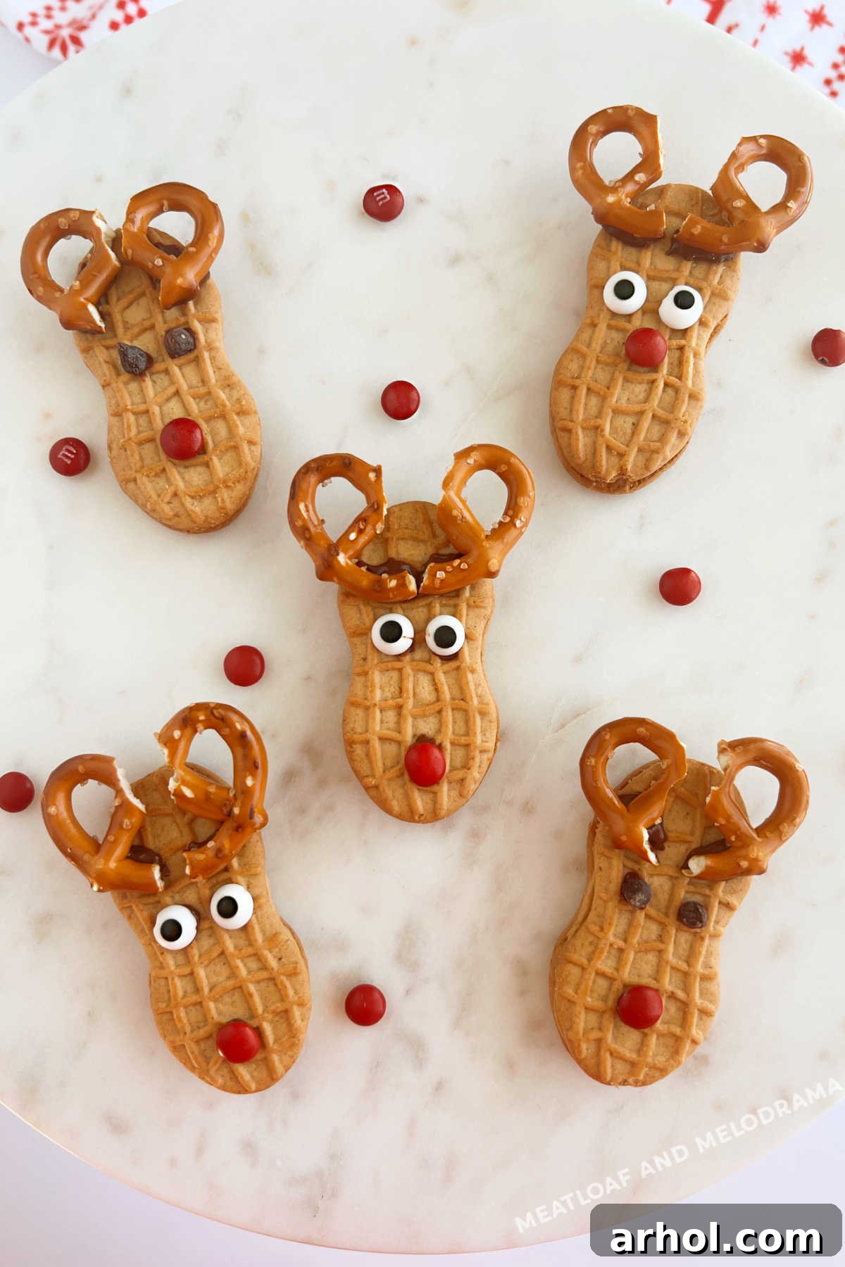 nutter butter reindeer cookies with pretzel antlers and red candy noses on platter