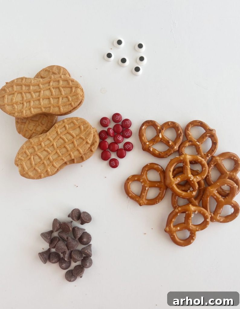 peanut butter cookies, chocolate, candy eyes, pretzels and red m and ms on the table