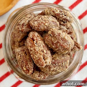 Candied pecans coated in cinnamon sugar mixture in a mason jar, highlighting their delicious texture and readiness for enjoyment.