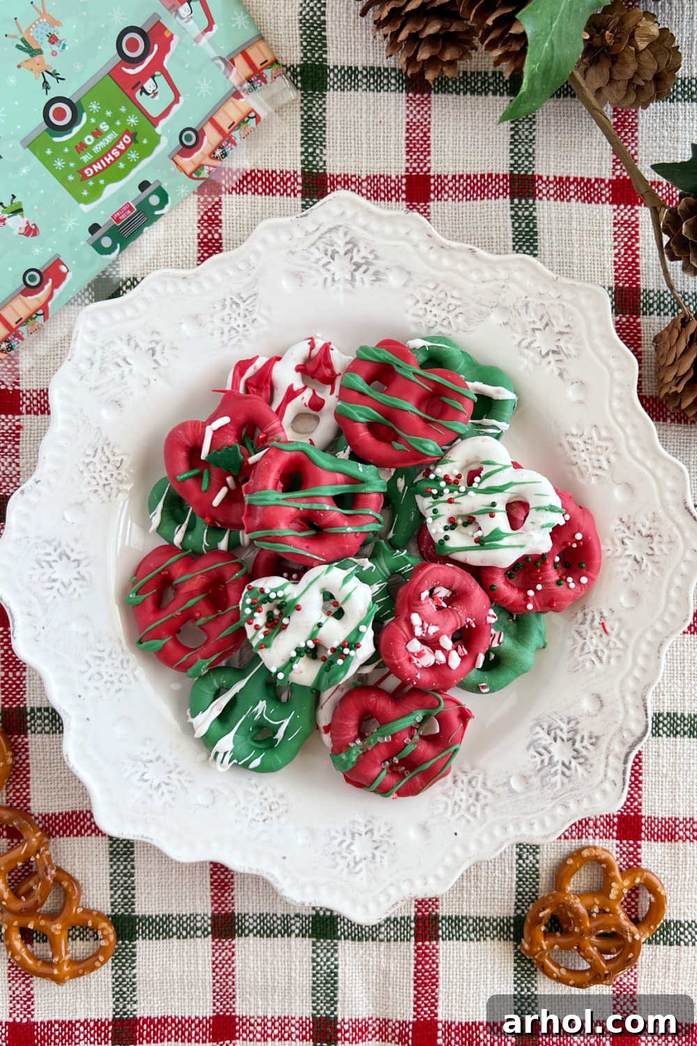 A festive plate of chocolate covered Christmas pretzels adorned with colorful sprinkles, a perfect holiday treat
