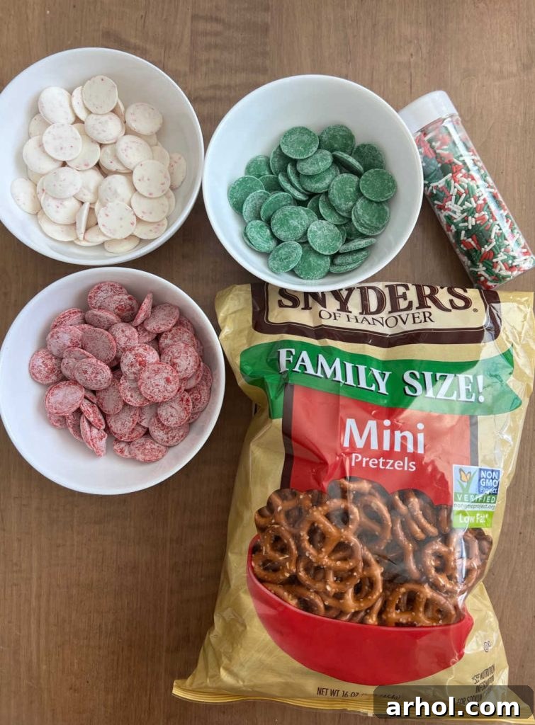Mini pretzels, vibrant holiday candy melts, and an assortment of festive sprinkles laid out for decorating