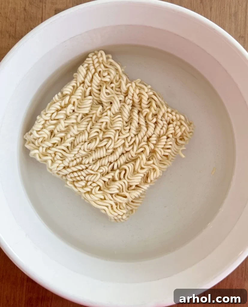 uncooked instant ramen noodles in bowl of water