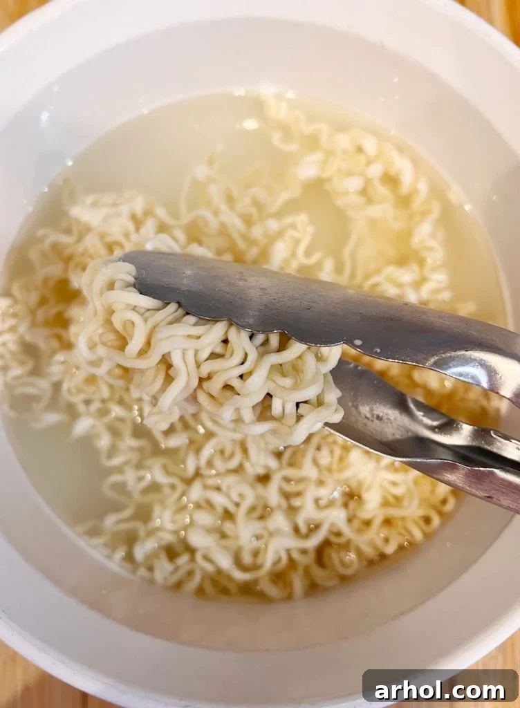 cooked ramen noodles in kitchen tongs