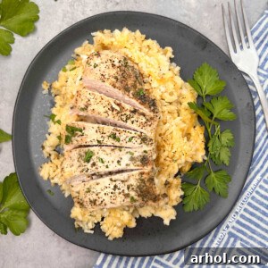 Grandma's one-pan no peek chicken and rice served on a black plate with fresh parsley garnish.