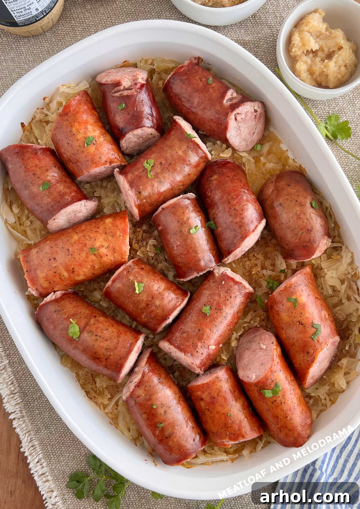Polska kielbasa and sauerkraut in casserole dish with side of horseradish on the table