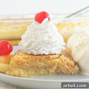 pineapple dump cake with whipped cream and maraschino cherry on top