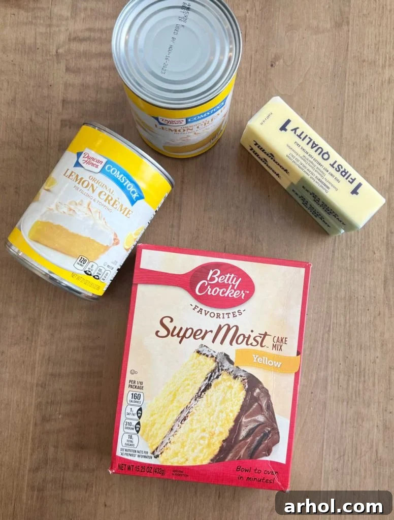Simple Lemon Dump Cake Ingredients Yellow cake mix, two cans of lemon pie filling, and sticks of butter laid out on a table, showcasing the simple ingredients for the dump cake.
