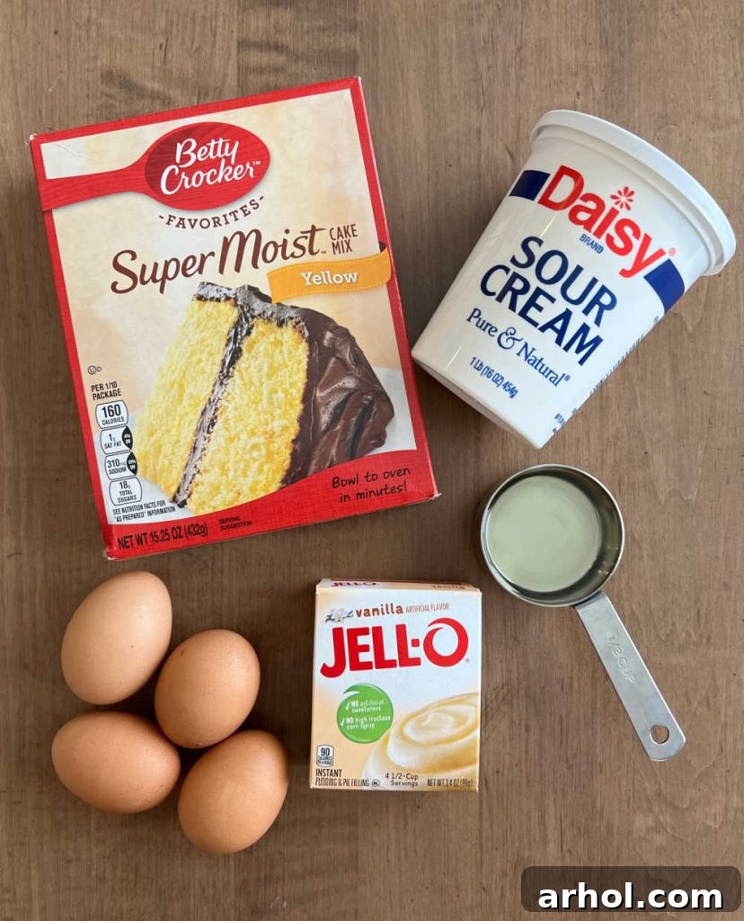 Irresistible Easter Lamb Cake 3 Essential ingredients for the Easter Lamb Cake: yellow cake mix, sour cream, vegetable oil, instant vanilla pudding mix, and eggs, laid out on a kitchen counter