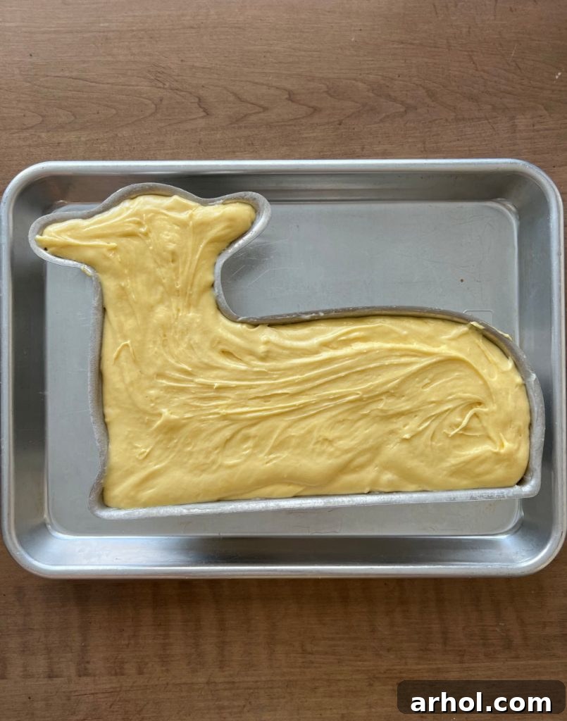 Irresistible Easter Lamb Cake 6 Thick pound cake batter carefully spooned into the bottom half of a lamb cake pan, resting on a baking sheet