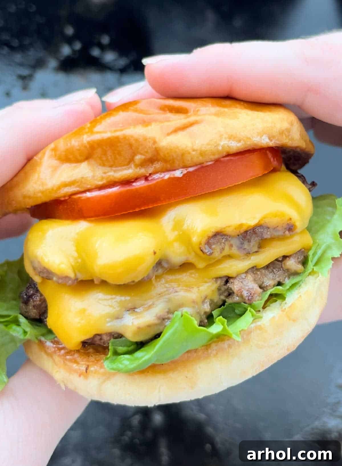 double smash burger with cheese in hand, showcasing crispy edges and melted cheese.