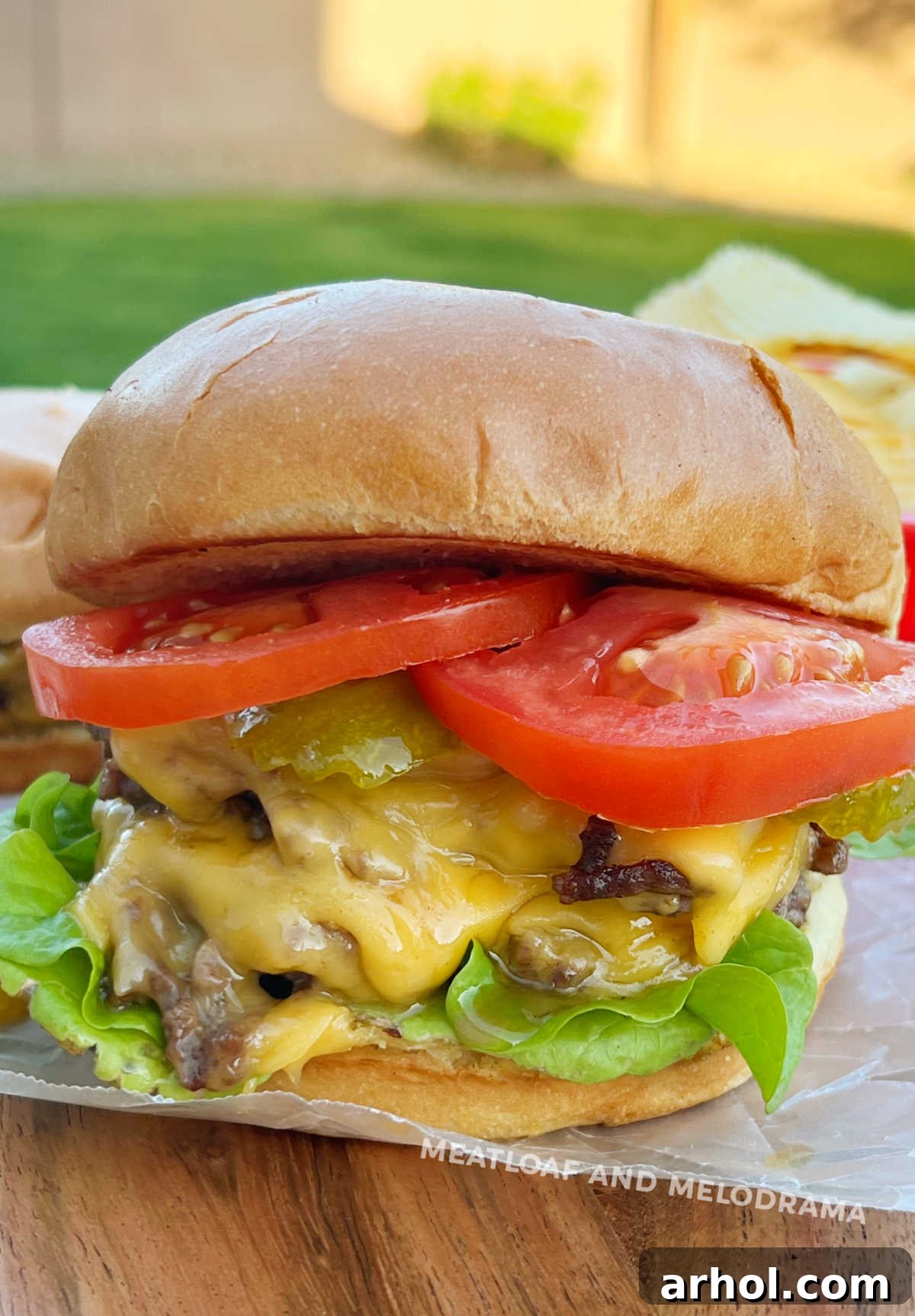 blackstone griddle smash burger with cheese, lettuce, and tomatoes, perfectly assembled.