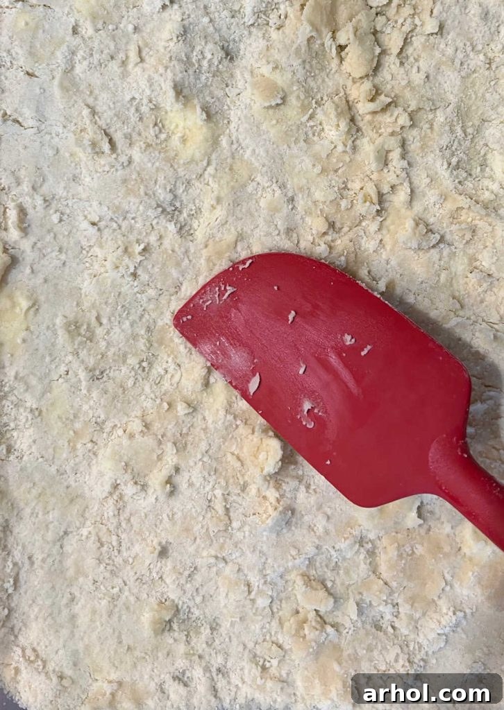 Pressing flour and butter mixture evenly into a baking pan to form the shortbread crust.
