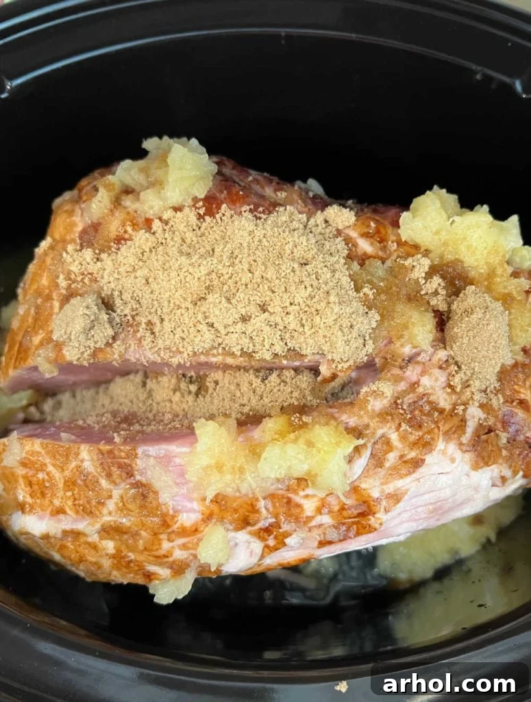 A spiral cut ham covered with a generous layer of brown sugar and crushed pineapple.