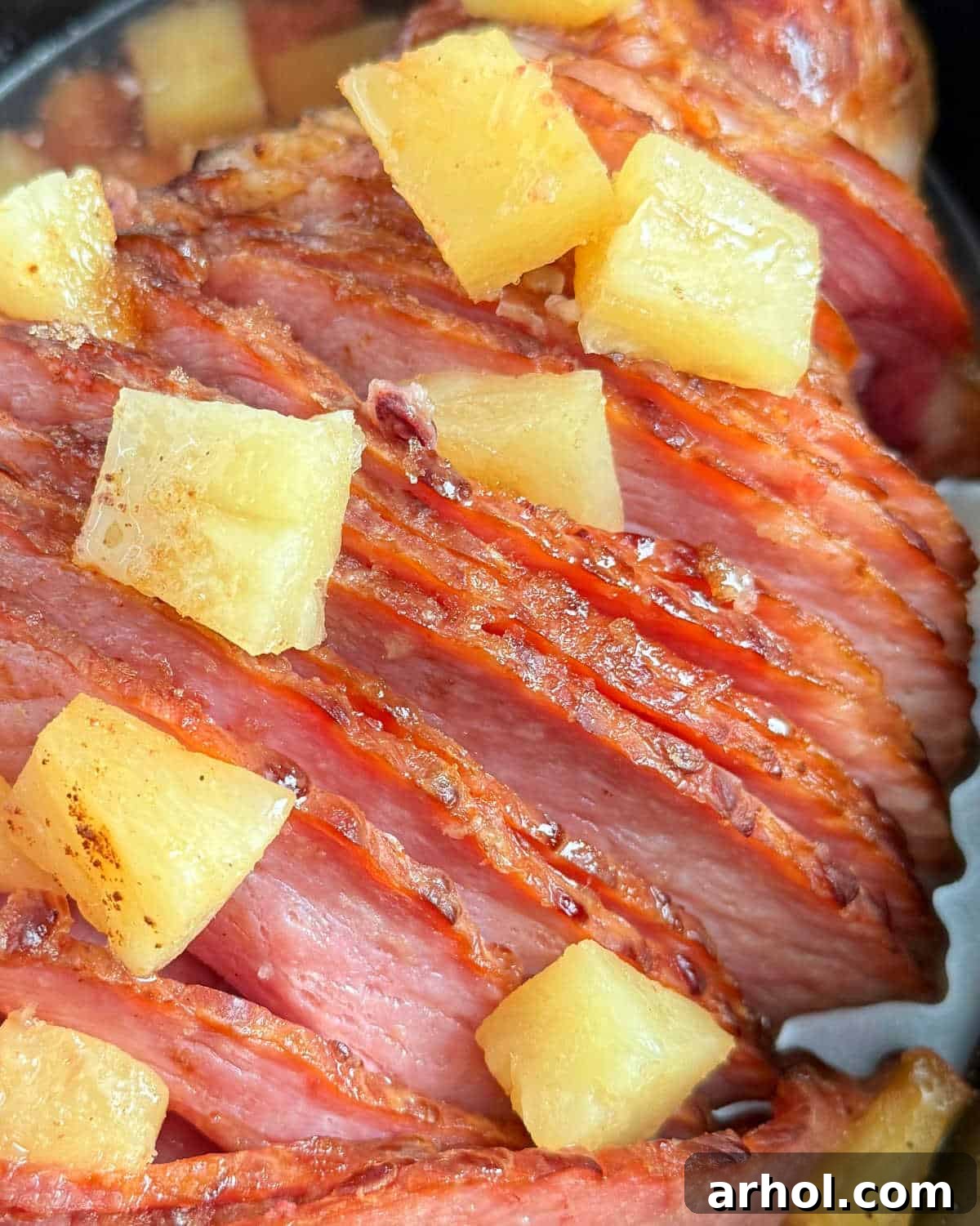 A beautifully glazed spiral ham with pineapple in a slow cooker, ready to serve.