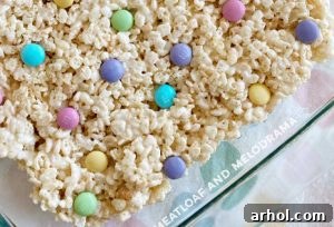 Cereal treats setting in the pan after candies are pressed in.