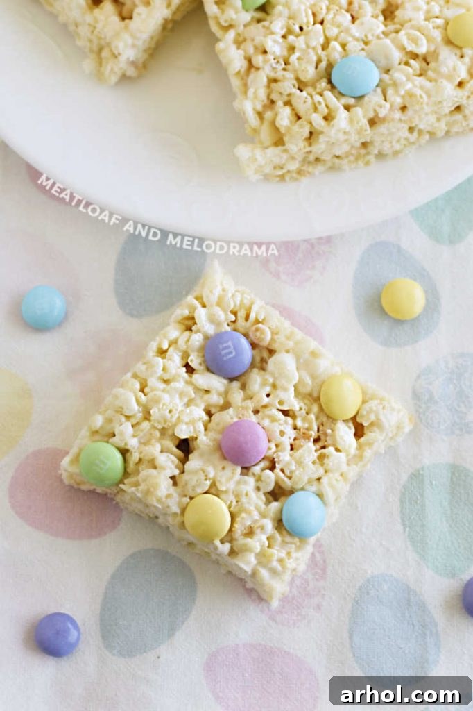 A single Spring Marshmallow Rice Krispies bar with pastel M&M's rests on a soft pastel napkin.