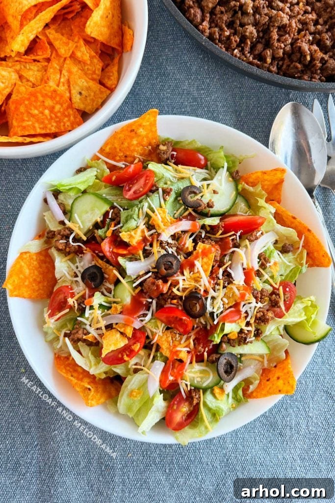taco salad with catalina dressing and doritos and ground beef on the table