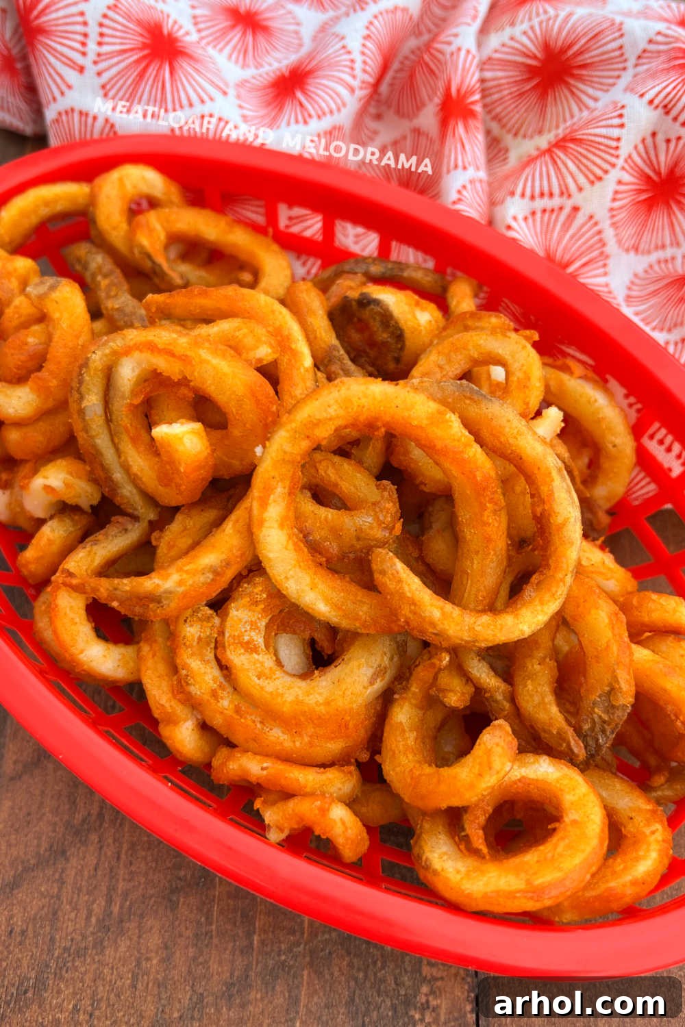 Crispy air fryer frozen curly fries served in a red basket, ready to eat.