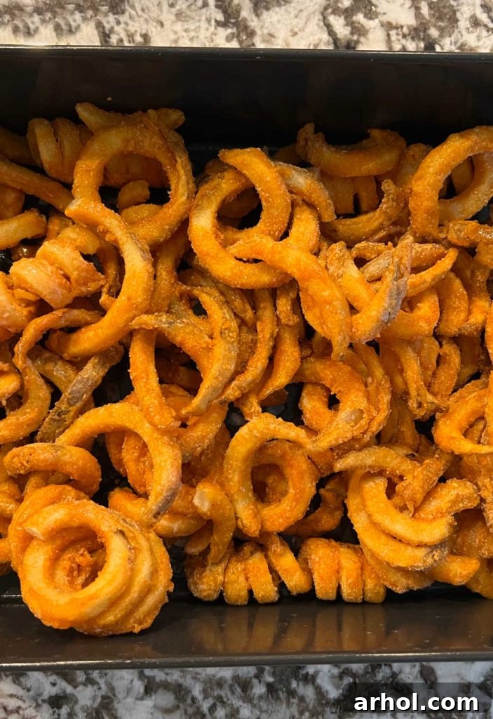 Frozen curly fries placed directly into an air fryer basket, ready for cooking.